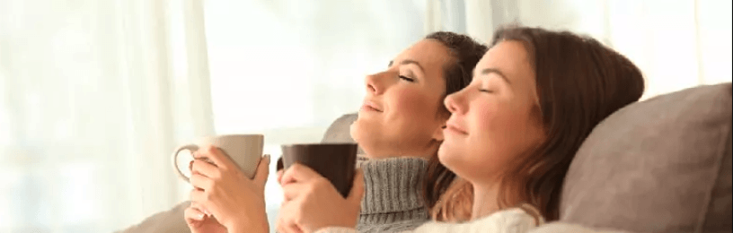 Two women recline with mugs