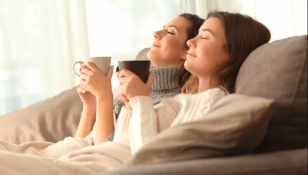 Two women recline with mugs